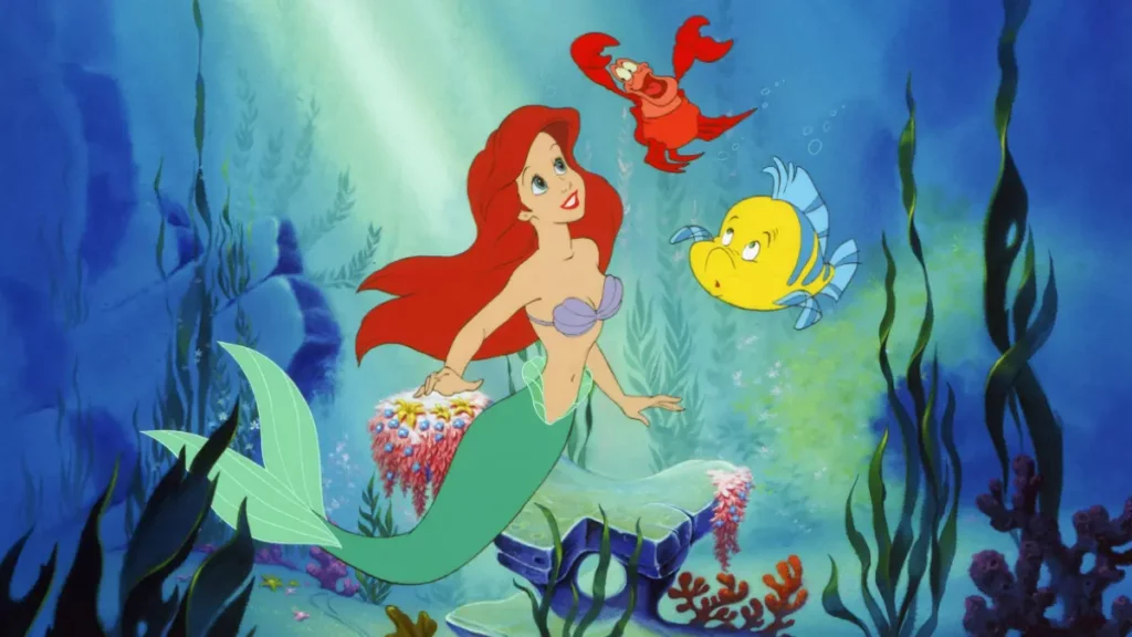 Ariel ao lado de Sebastião e Linguado em cena de A Pequena Sereia.