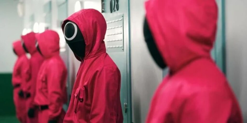 Pessoas em protesto na Coreia do Sul usam roupas de Round 6 Cena de Round 6 (Reprodução / Netflix)