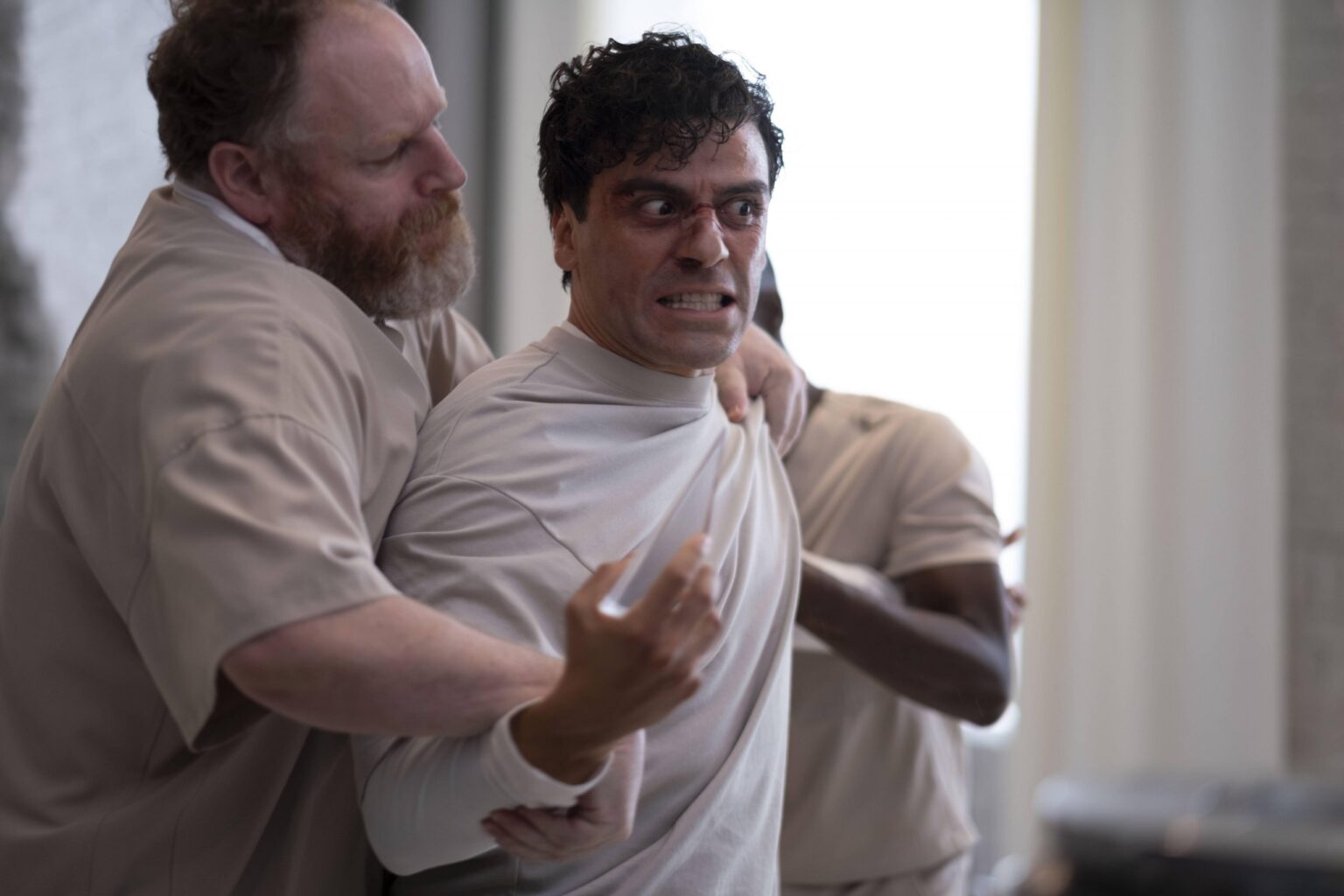 David Ganly como Billy Fitzgerald, Oscar Isaac como Marc Spector/Steven Grant, e Ann Akin como Bobbi Kennedy em Cavaleiro da Lua