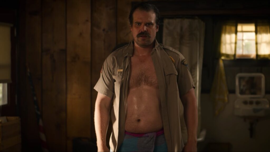 Ator de Stranger Things emagrece muito, chateia fãs, e promete: “Barriguinha vai voltar” David Harbour é Jim Hopper em Stranger Things (Reprodução)