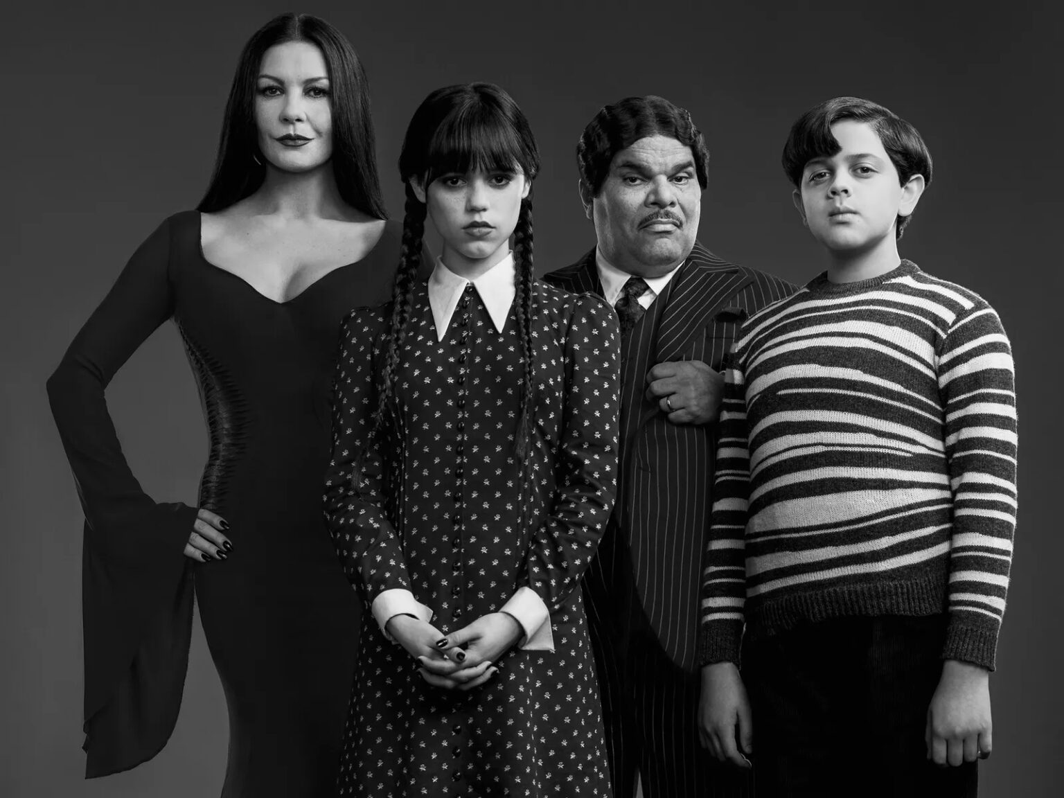 Wandinha não é um reboot de Família Addams, explicam criadores Jenna Ortega como Wandinha, Catherine Zeta-Jones como Mortícia, Luis Guzmán como Gomez e Isaac Ordonez como Feioso em Wednesday (Divulgação / Netflix)