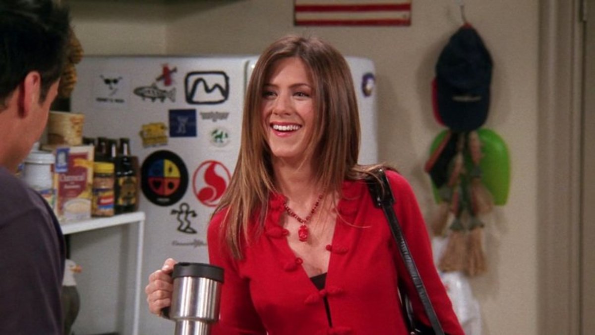 Rachel sorri com um copo de café na mão, enquanto conversa com Joe em cena de Friends