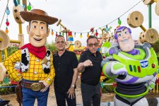Tom Hanks e Tim Allen posam ao lado de bonecos de seus personagens de parque temático de Toy Story