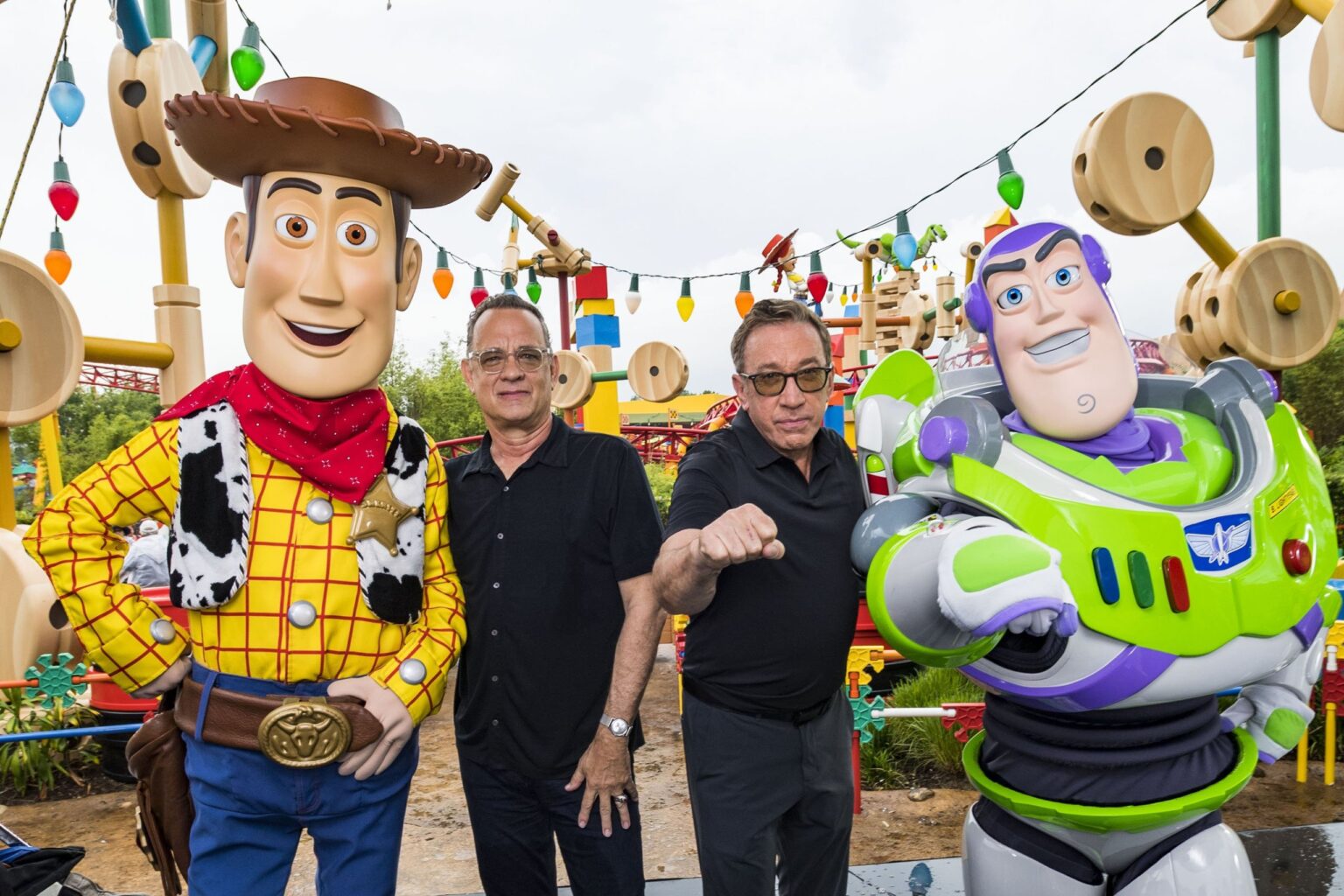Toy Story: Tim Allen e Tom Hanks são amigos de verdade? Tom Hanks e Tim Allen posam ao lado de bonecos de seus personagens de parque temático de Toy Story