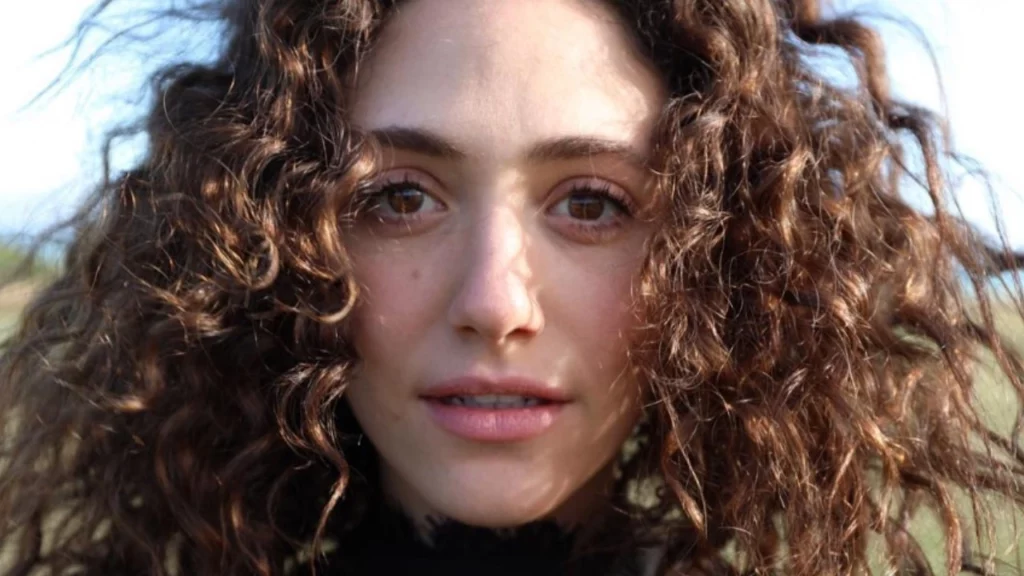 Por que Emmy Rossum saiu de Shameless? A verdade completa 1 Retrato feminino em close ao ar livre para conteúdo sobre Emmy Rossum.