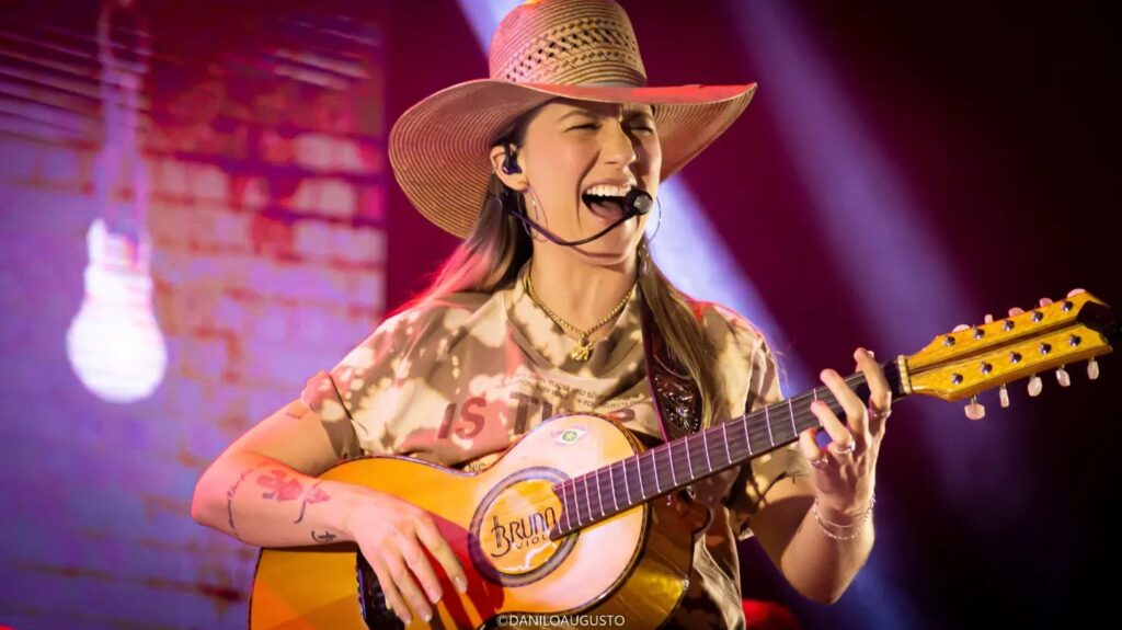 Bruna Viola cantando e tocando violão em um de seus shows