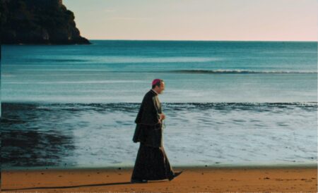 Filme comprova merecimento de santificação de Santo abolicionista Cartaz de O santo de todos - A vida e missão de Santo Antônio Maria Claret mostra arcebispo caminhando na beira da praia