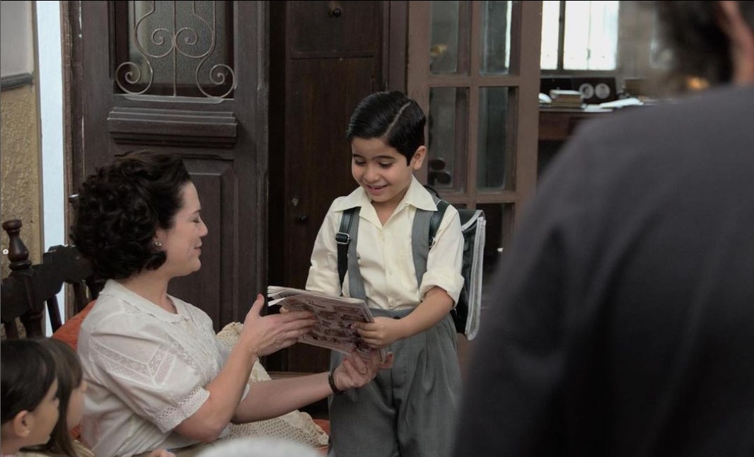 Mauricio de Sousa será vivido pelo próprio filho em novo filme 2 Uma criança mostra uma revista em quadrinhos para a mãe que sorri em cena da cinebiografia de Maurício de Sousa