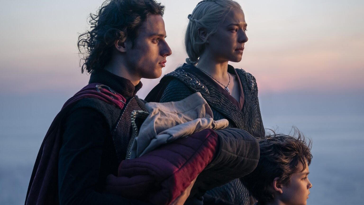 Ator comenta a árvore genealógica complicada da família Targaryen Oscar Eskinazi, Harry Collett, e Emma D'Arcy em A Casa do Dragão (Reprodução / HBO)