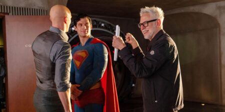 Filmes da DC: ordem do DCEU e do novo DCU explicada Nos bastidores da filmagem de Superman (2025), um dos novos filmes da DC, Nicholas Hoult aparece caracterizado como Lex Luthor, de costas, enquanto David Corenswet, no traje completo de Superman, conversa com o diretor James Gunn, que sorri de óculos e barba grisalha enquanto segura páginas do roteiro.