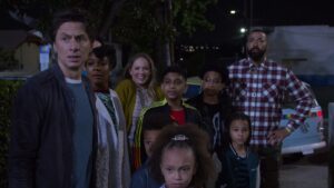 Sessão da Tarde de hoje exibe Doze É Demais, com Zach Braff; veja detalhes do remake Zach Braff (Paul Baker), Gabrielle Union (Zoe Baker) e Erika Christensen (Kate) aparecem com as crianças e o ex-marido Dom (interpretado por Timon Kyle Durrett) em uma cena noturna de Doze é Demais (2022). O grupo observa algo com expressões de surpresa e curiosidade em uma rua iluminada por postes.