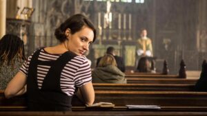 Fleabag olha para a câmera enquanto está sentada em um banco de igreja durante uma das cenas mais marcantes da série.