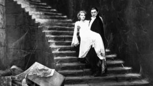 Filmes de terror clássicos: 10 obras que definiram o gênero Cena do filme Drácula (1931), com o vampiro carregando uma jovem em uma escadaria sombria, símbolo do início da era dos monstros no cinema de terror.
