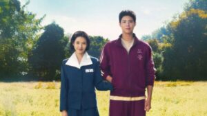 Casal de protagonistas de "Se a Vida Te Der Tangerinas" em um campo ensolarado, cena romântica de um dos melhores doramas de 2025.