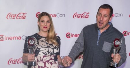 Drew Barrymore e Adam Sandler posam juntos segurando troféus em evento do CinemaCon.