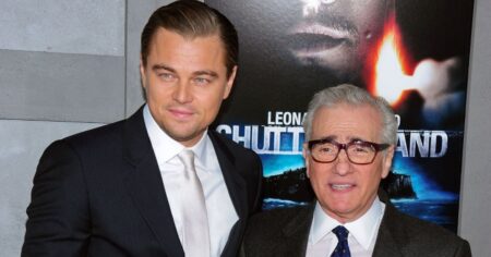 Leonardo DiCaprio posa ao lado do diretor Martin Scorsese durante evento de cinema, ambos usando trajes formais diante de um painel promocional ao fundo