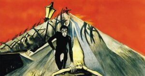 Cena do filme O Gabinete do Dr. Caligari, com figura sombria inclinada sobre uma mulher, em cenário expressionista com formas distorcidas e atmosfera inquietante; um dos filmes de terror no youtube
