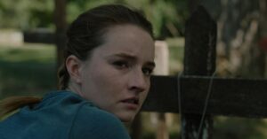 The Last of Us 3 temporada: status, onde assistir, elenco e episódios Mulher jovem em ambiente rural pós-apocalíptico demonstra tensão e tristeza, refletindo o tom dramático da série.