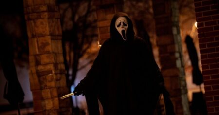 Ghostface aparece encapuzado segurando faca em cena noturna do filme Pânico 7