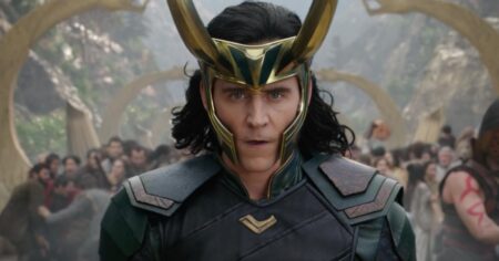 Ator Tom Hiddleston caracterizado como Loki, usando traje verde e dourado, em cena épica do universo Marvel