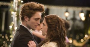 Crepúsculo retorna aos cinemas brasileiros; confira a data Edward Cullen e Bella Swan se encaram durante cena romântica do filme Crepúsculo, em ambiente iluminado por luzes decorativas durante baile