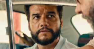 O Agente Secreto confirma estreia na Netflix após trajetória histórica no cinema Wagner Moura em cena do filme O Agente Secreto, sentado no banco traseiro de um carro e olhando com expressão tensa durante diálogo