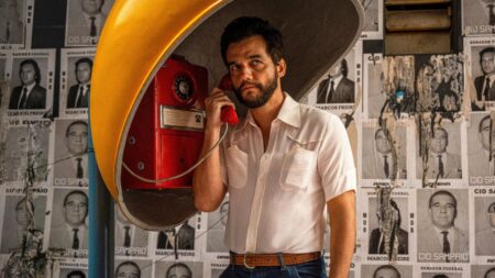 Wagner moura em "O Agente Secreto” em cena dramática usando telefone público, imagem relacionada à polêmica do filme no Oscar 2026