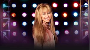 Miley Cyrus anuncia especial de 20 anos de Hannah Montana; veja o trailer Miley Cyrus caracterizada como Hannah Montana sorri diante de um palco com luzes coloridas ao fundo, em imagem promocional da série teen do Disney Channel.