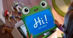 Cena de Toy Story 5 mostra Bonnie segurando o tablet infantil LilyPad enquanto Woody e Buzz aparecem caídos ao fundo no quarto