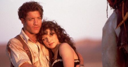 Brendan Fraser e Rachel Weisz abraçados em cena de A Múmia no deserto, em imagem clássica do filme de 1999