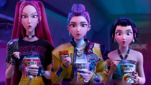 personagens animadas Mira, Rumi e Zoey aparecem lado a lado segurando copos de macarrão instantâneo e reagindo surpresas em cena da animação Guerreiras do K‑Pop.