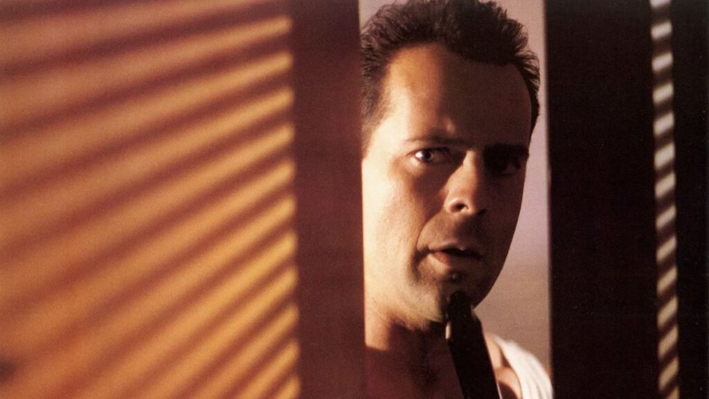 Melhores filmes de ação: 50 títulos imperdíveis para quem ama adrenalina Bruce Willys em cena misteriosa de Duro de Matar compondo a lista de melhores filmes de ação