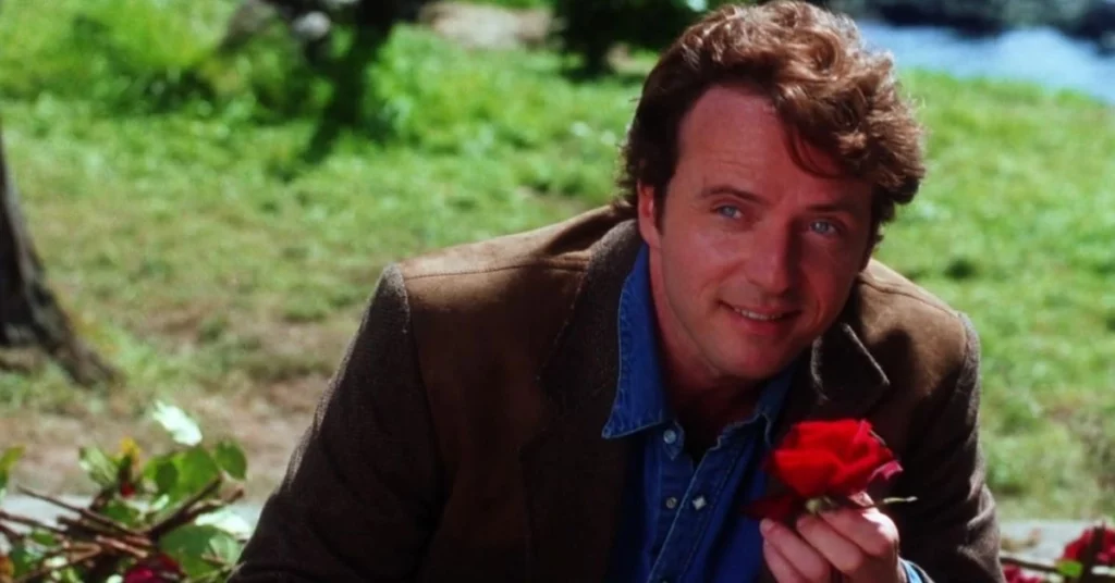 Aidan Quinn como Gary Hallet segurando uma rosa em cena do filme Da Magia à Sedução