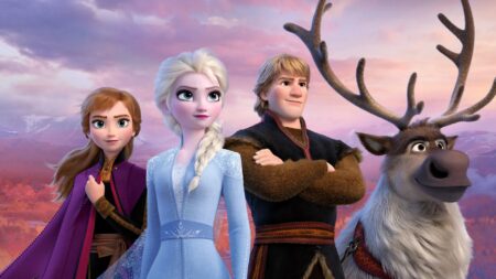 Personagens de Frozen II. Elsa, Anna, Kristoff e a rena Sven posam juntos em cenário montanhoso ao pôr do sol, com céu em tons de rosa e roxo ao fundo
