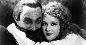 Filmes de terror antigos: 25 clássicos que definiram o gênero ao longo das décadas Conrad Veidt como Gwynplaine em O Homem que Ri (1928), com expressão marcada pelo sorriso permanente ao lado de personagem feminina