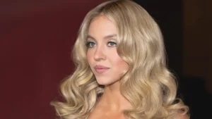 Sydney Sweeney em close com cabelo loiro ondulado