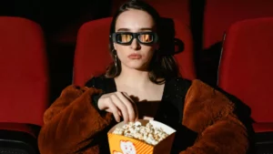 Assistir filmes grátis legalmente: entenda tudo sobre o tema Pessoas com pipoca em sala de cinema em pauta sobre assistir filmes grátis legalmente