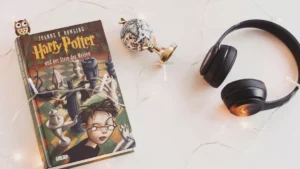 Série Harry Potter: elenco, estreia e tudo sobre a nova adaptação da HBO Minimalist setup com Harry Potter book, headcelulars, e string lights for a aconchegante reading experience. em pauta sobre