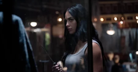 Pânico 7: Melissa Barrera rebate estúdio e critica volta do elenco Melissa Barrera aparece como Sam Carpenter em cena escura de Pânico, segurando uma faca diante de vidro