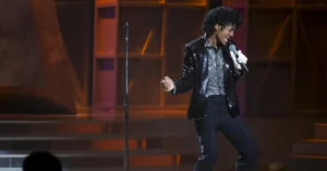 Michael vai ganhar sequência ‘grande e satisfatória’, garante executivo Jaafar Jackson caracterizado como Michael Jackson durante apresentação no palco em cena da cinebiografia Michael.
