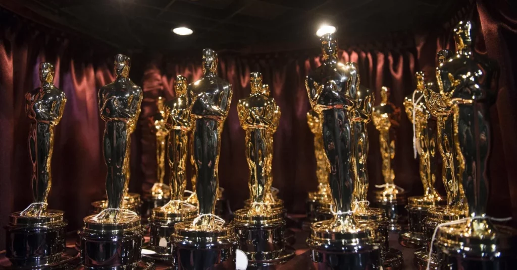 Oscar 2027 muda regra histórica e cria novo caminho para filmes internacionais; entenda Estatuetas douradas do Oscar aparecem iluminadas em bastidor da premiação, com cortinas escuras ao fundo