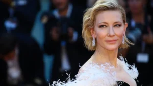 Cate Blanchett revela crítica dura de diretor em set com Brad Pitt; veja Cate Blanchett posa em evento no tapete vermelho usando vestido claro e brincos brilhantes.