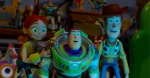 Toy Story 5 faz história, bate US$ 1 bilhão e conquista o maior feito de 2026 Jessie, Buzz Lightyear e Woody aparecem juntos em cena de Toy Story 5, cercados por outros brinquedos em ambiente iluminado por tons azulados