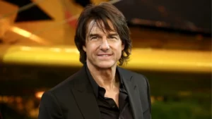 Tom Cruise surge irreconhecível em novo filme e visual impressiona; veja Tom Cruise posa para fotógrafos durante um evento usando terno preto e camisa escura.