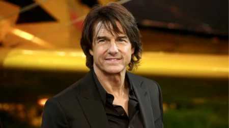 Tom Cruise surge irreconhecível em novo filme e visual impressiona; veja Tom Cruise posa para fotógrafos durante um evento usando terno preto e camisa escura.