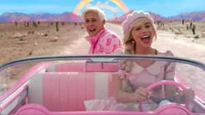 Barbie 2 pode perder Margot Robbie e Ryan Gosling após impasse com a Warner; entenda Margot Robbie e Ryan Gosling caracterizados como Barbie e Ken em cena do filme Barbie, dirigindo um conversível rosa em Barbieland.