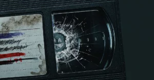 Tela quebrada com símbolo de Black Mirror ao lado de um cartão com anotações