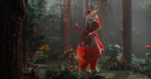 Buddy ganha teaser inquietante dos produtores de A Hora do Mal; assista Personagem Buddy, vestido com uma fantasia vermelha e branca de aparência infantil e com um chifre na cabeça, segura um machado enquanto caminha por uma floresta escura e enevoada