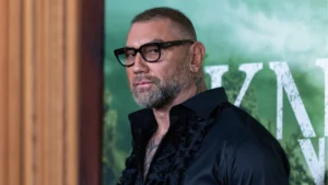 Dave Bautista pode assumir papel de Kratos após mudança na série de God of War Dave Bautista posa para fotógrafos durante um evento, usando camisa preta e óculos de armação escura.