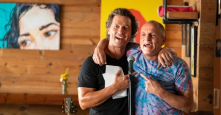 Matthew McConaughey e Woody Harrelson aparecem abraçados diante de um microfone em cena de Brothers